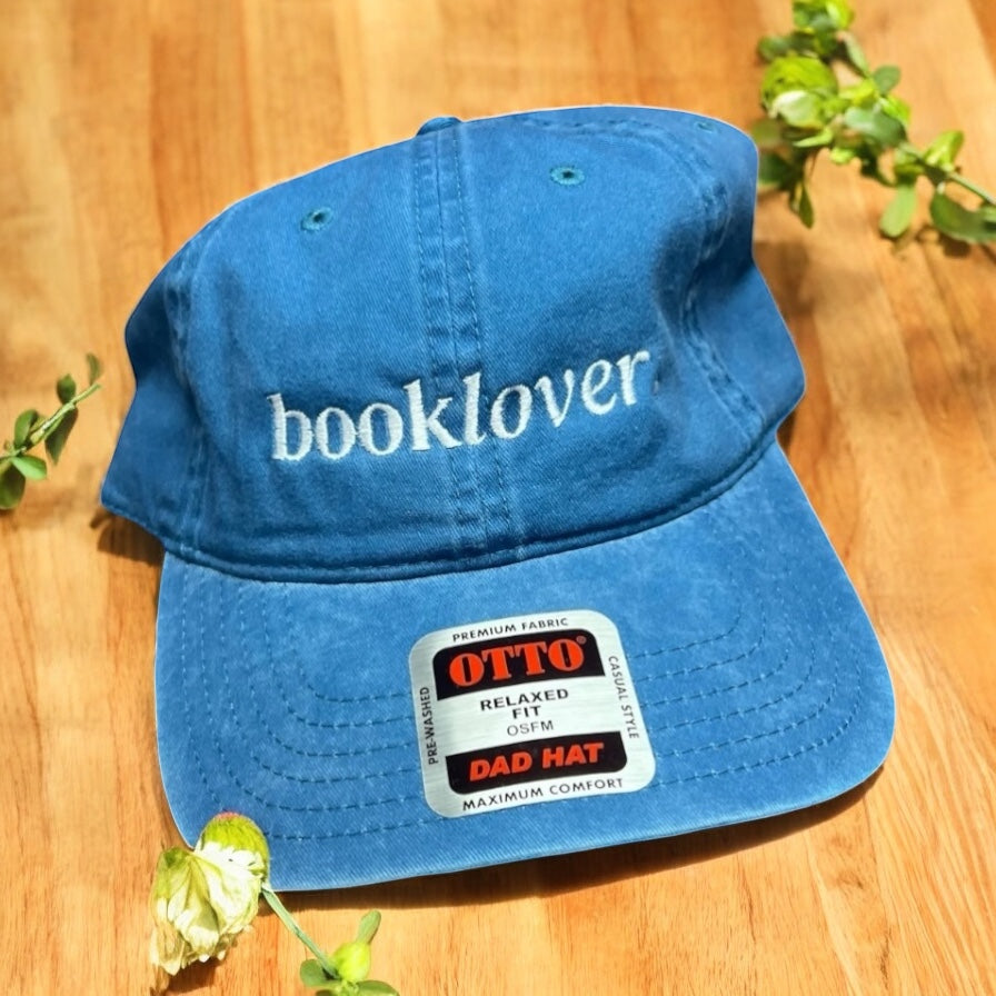 Blue cap with 'booklover' text on a wooden surface