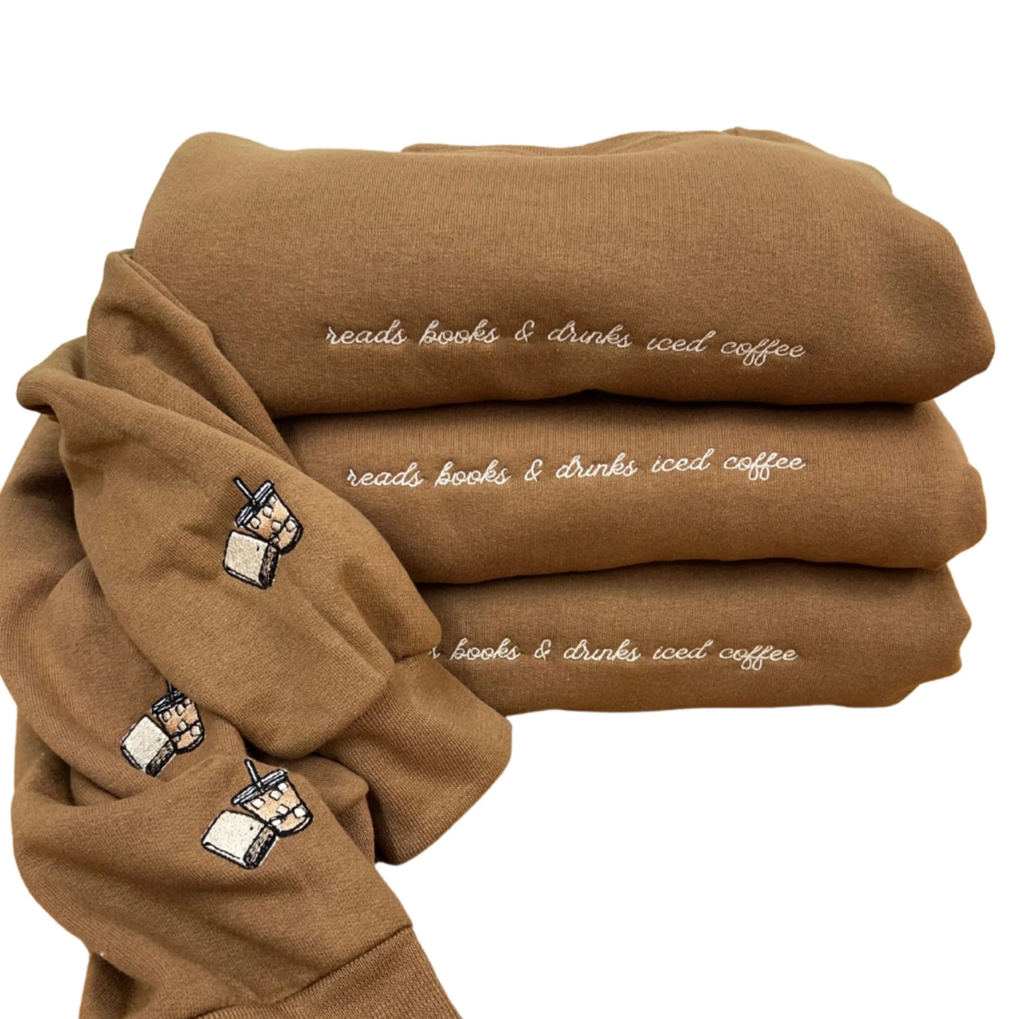 Stack of brown sweatshirts with embroidered text and coffee cup icons on a white background